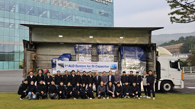 주성엔지니어링 임직원들이 지난해 10월 DTC 실리콘 커패시터용 ALD 장비 출하 후 기념 촬영을 하고 있는 모습. 주성엔지니어링 제공.